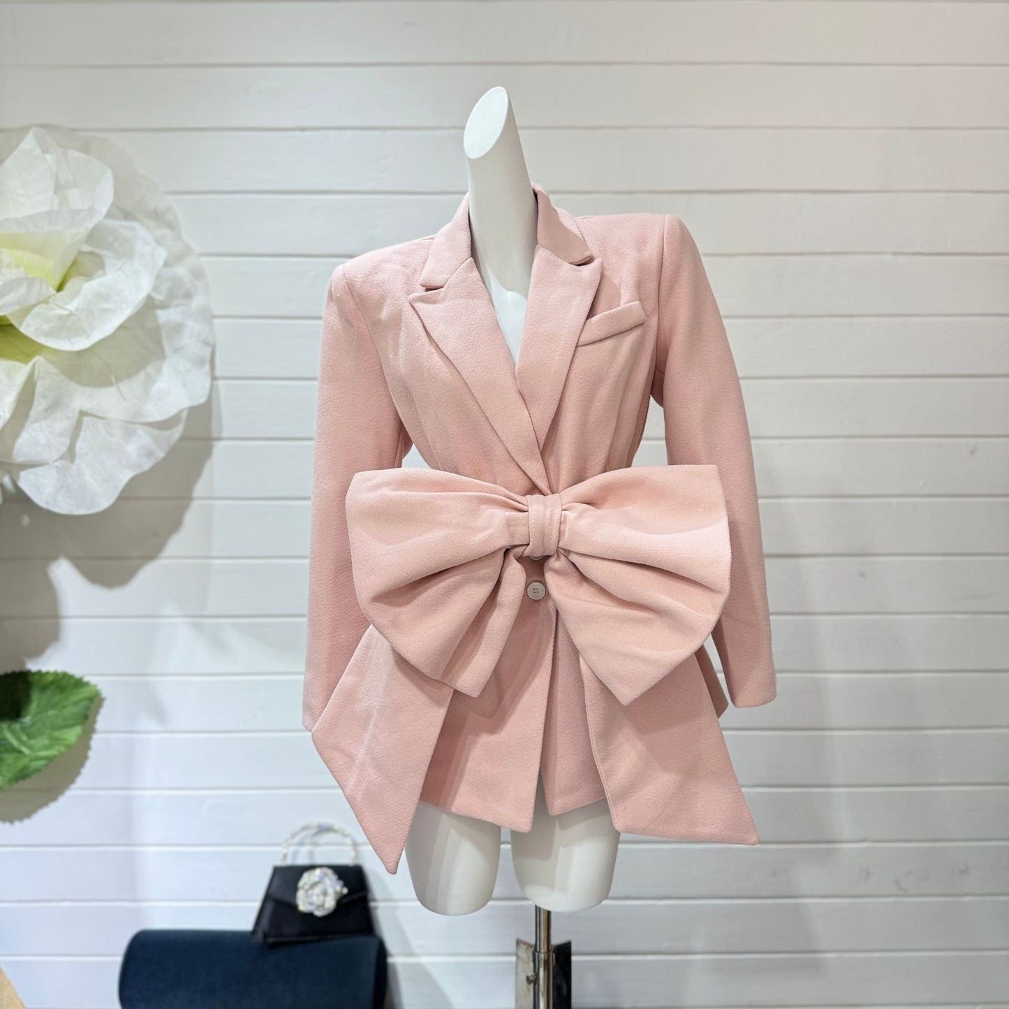 جاكيت نسائي بأكمام طويلة مزين بأزرار وربطة عنق مزخرفة، وياقة مدببة، وتطريز على شكل فيونكة.