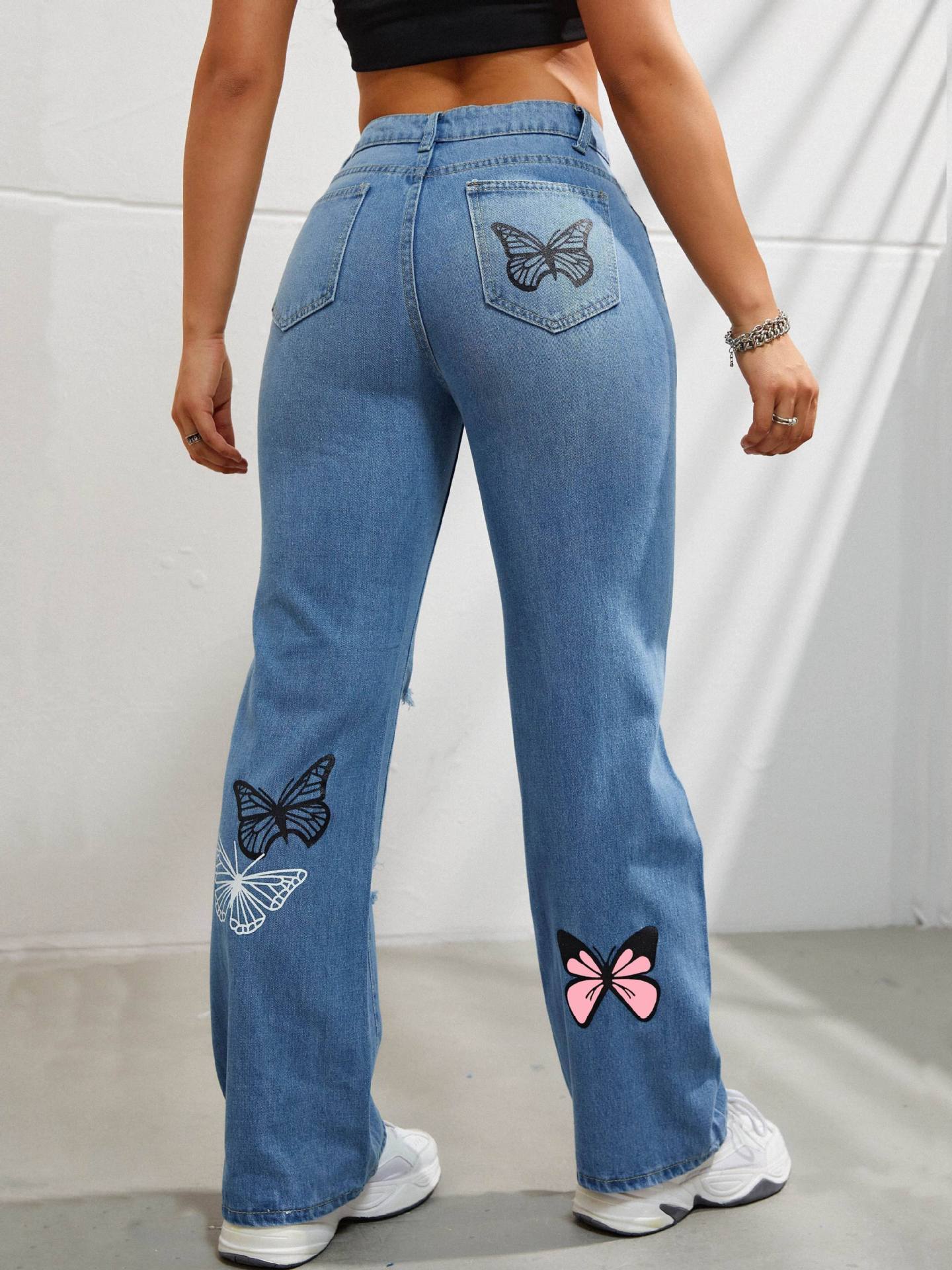 Jean droit taille haute en denim bleu pour femme avec imprimé papillon et déchirures usées