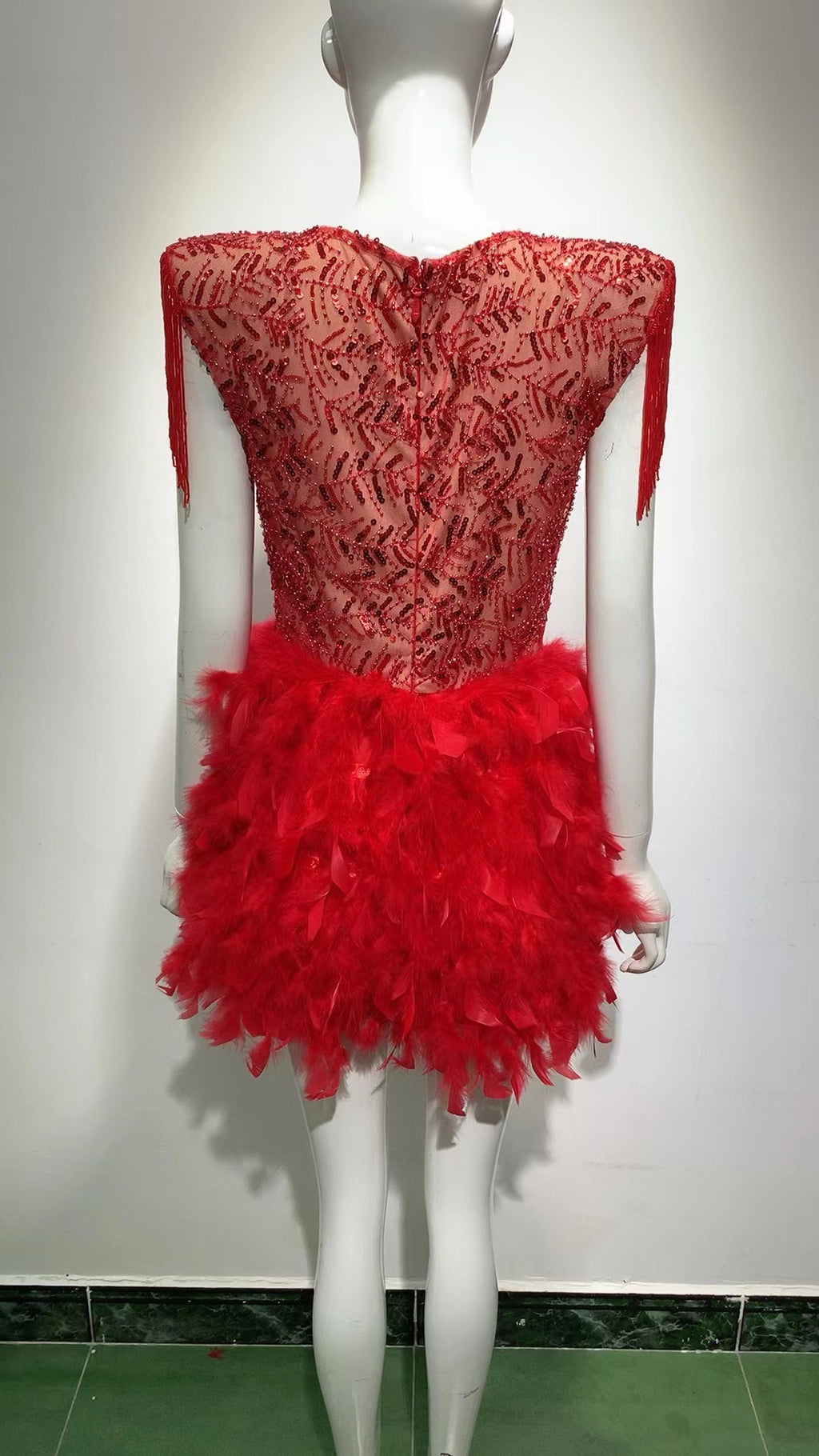 Robe courte sans manches rouge, décolleté en V profond, avec jupe à franges et plumes