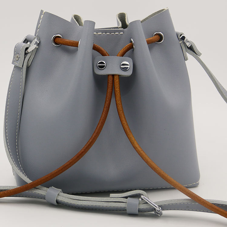 Sac seau en cuir de vachette surpiqué à la main, porté épaule/croisé