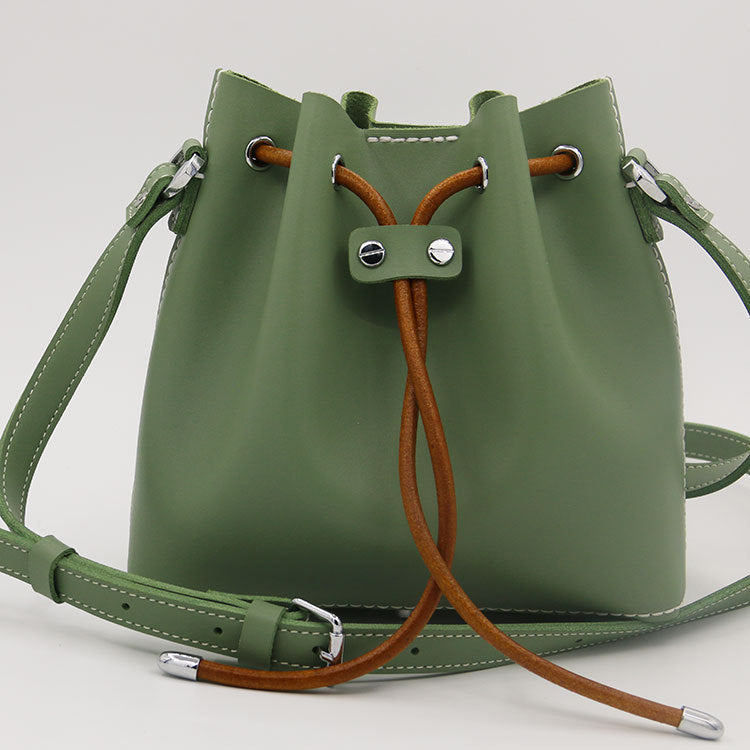 Sac seau en cuir de vachette surpiqué à la main, porté épaule/croisé