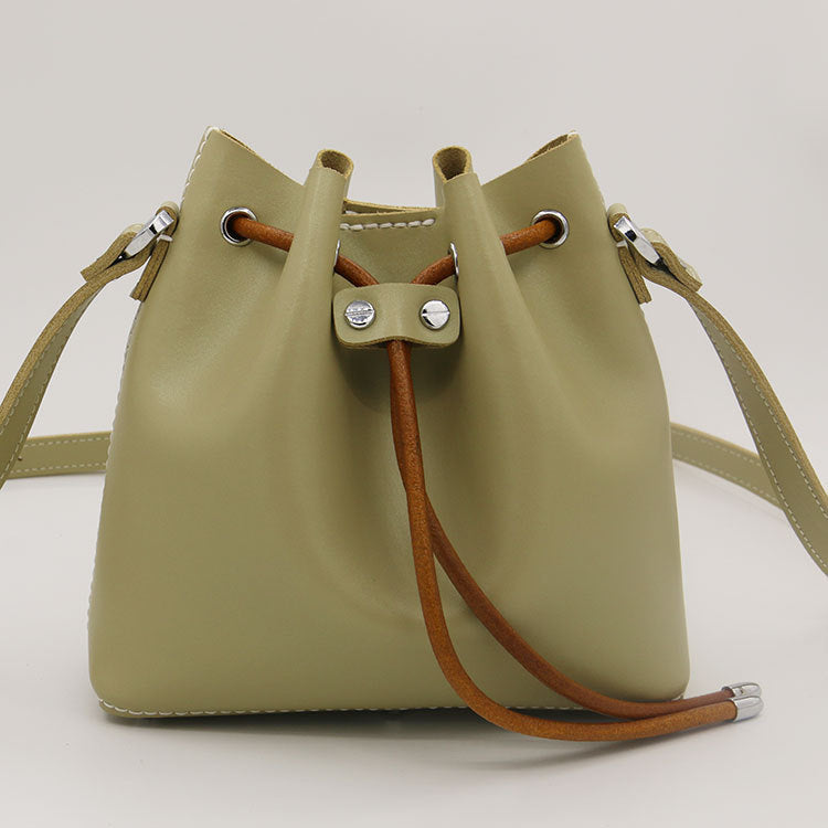 Sac seau en cuir de vachette surpiqué à la main, porté épaule/croisé