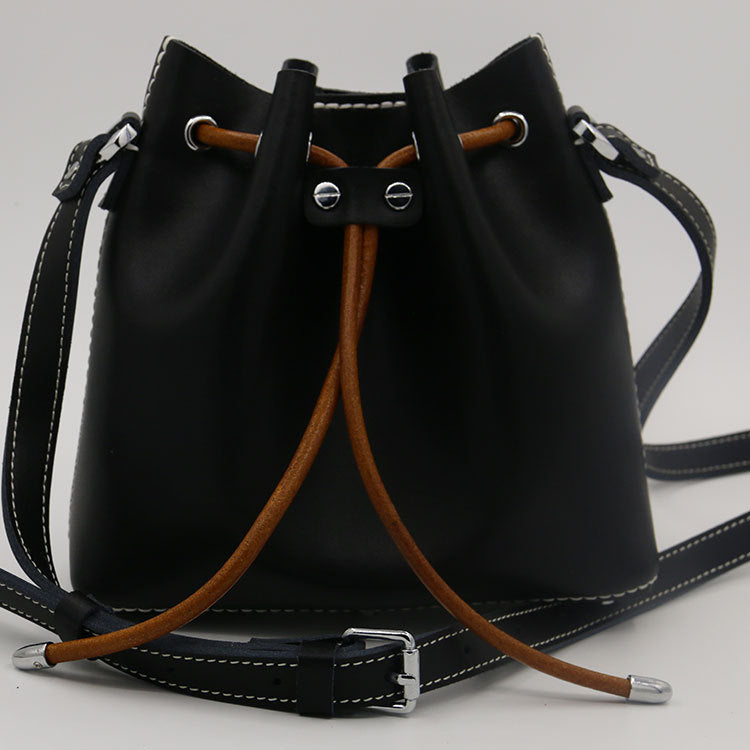 Sac seau en cuir de vachette surpiqué à la main, porté épaule/croisé