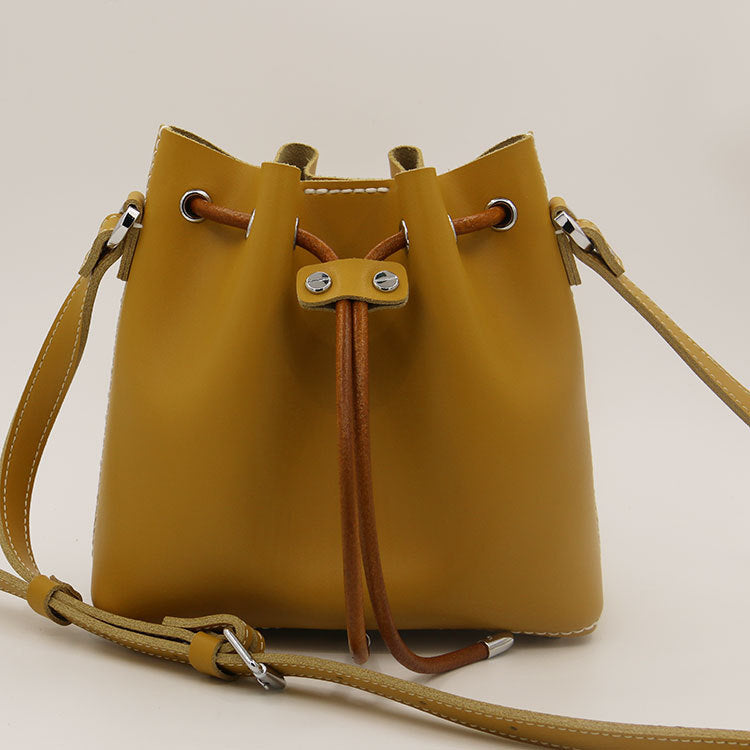 Sac seau en cuir de vachette surpiqué à la main, porté épaule/croisé