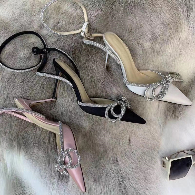 صندل أنيق بكعب عالٍ مزين بفيونكة وأحجار الراين الكريستالية، مصنوع من الساتان، مناسب للحفلات والمناسبات الرسمية.