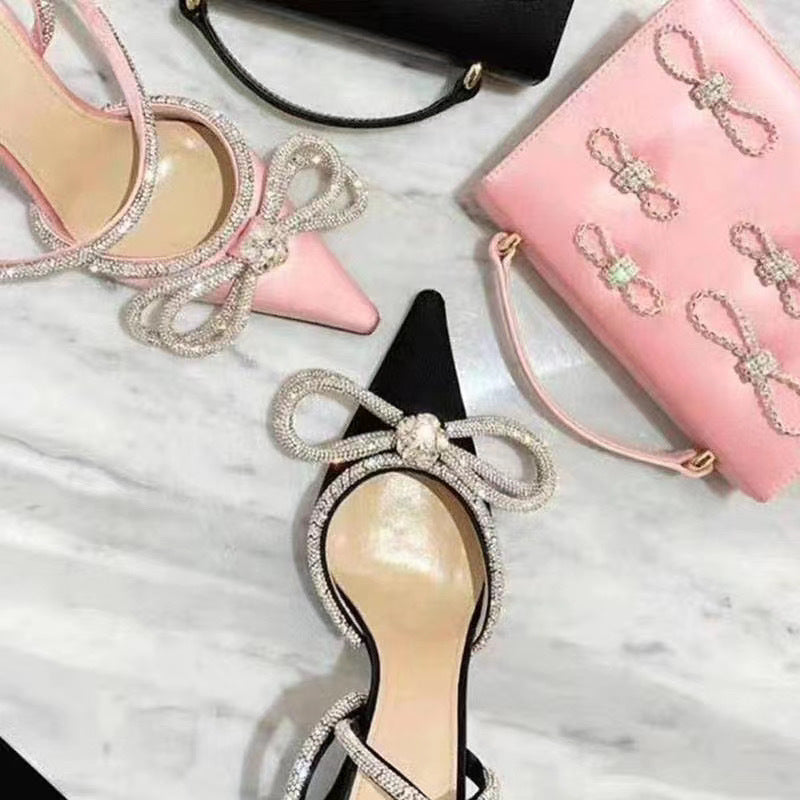 صندل أنيق بكعب عالٍ مزين بفيونكة وأحجار الراين الكريستالية، مصنوع من الساتان، مناسب للحفلات والمناسبات الرسمية.