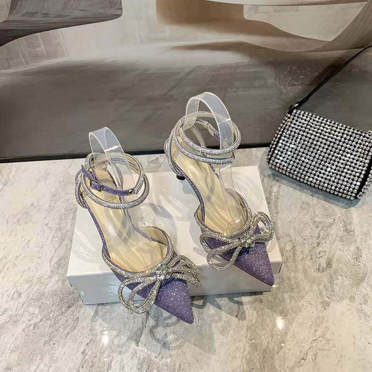 صندل أنيق بكعب عالٍ مزين بفيونكة وأحجار الراين الكريستالية، مصنوع من الساتان، مناسب للحفلات والمناسبات الرسمية.