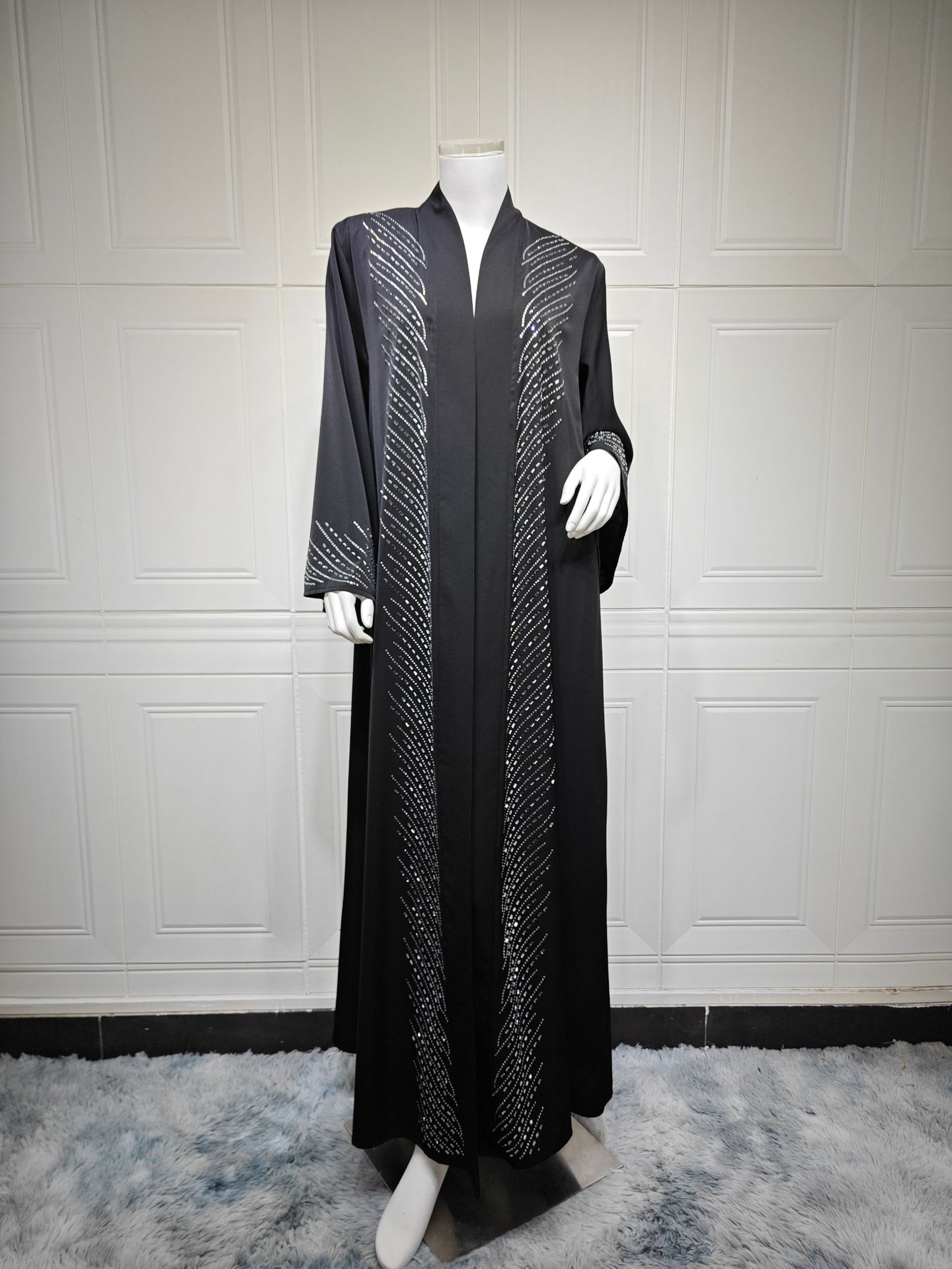Robe noire élégante du Moyen-Orient avec ornements en strass et manches évasées