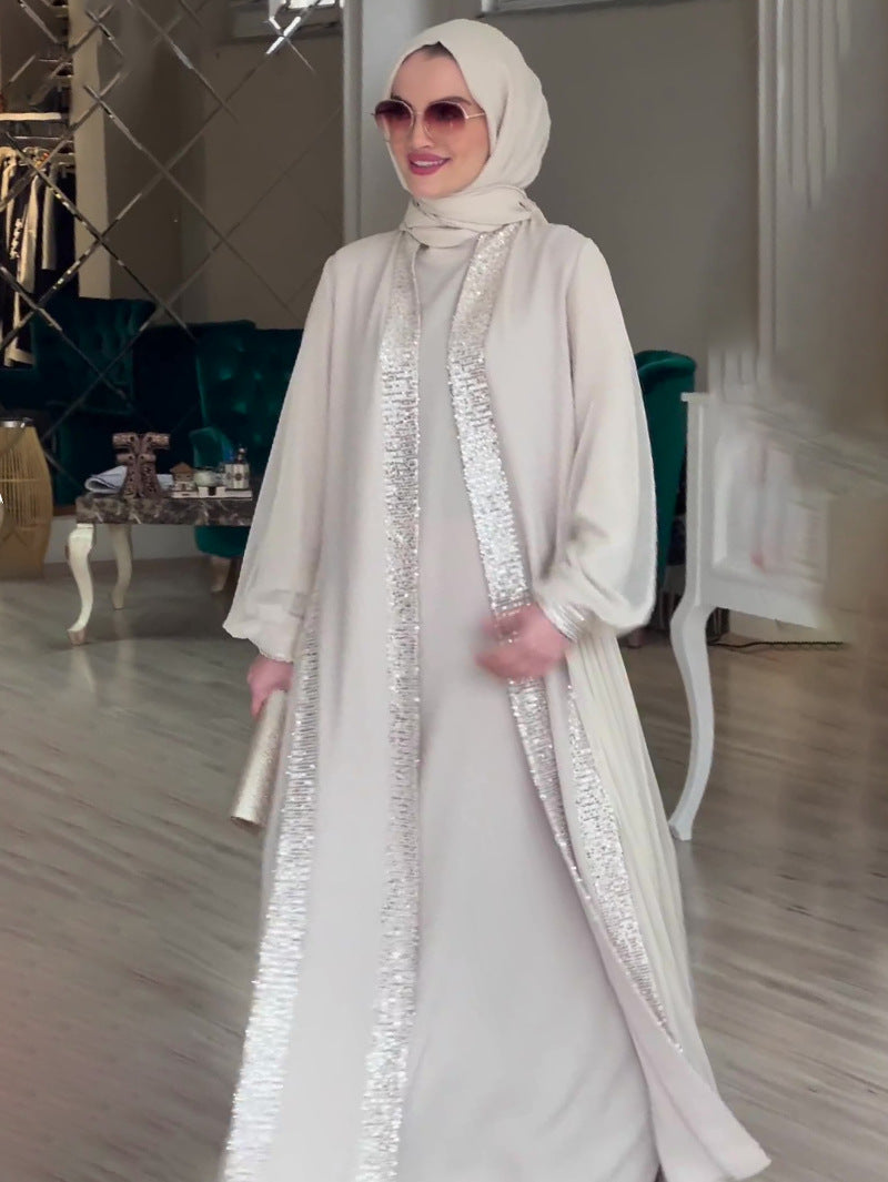 فستان فضفاض بأكمام طويلة ولون مشمشي سادة مزين بحلي لامعة