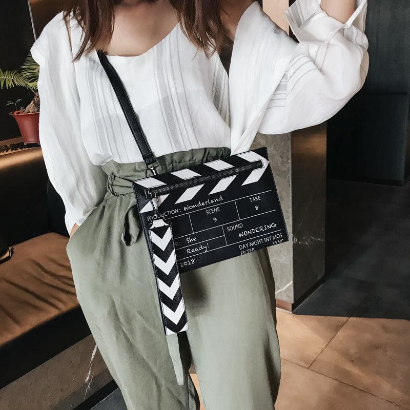 حقيبة يد نسائية من الجلد الصناعي بطبعة لوح تصوير سينمائي