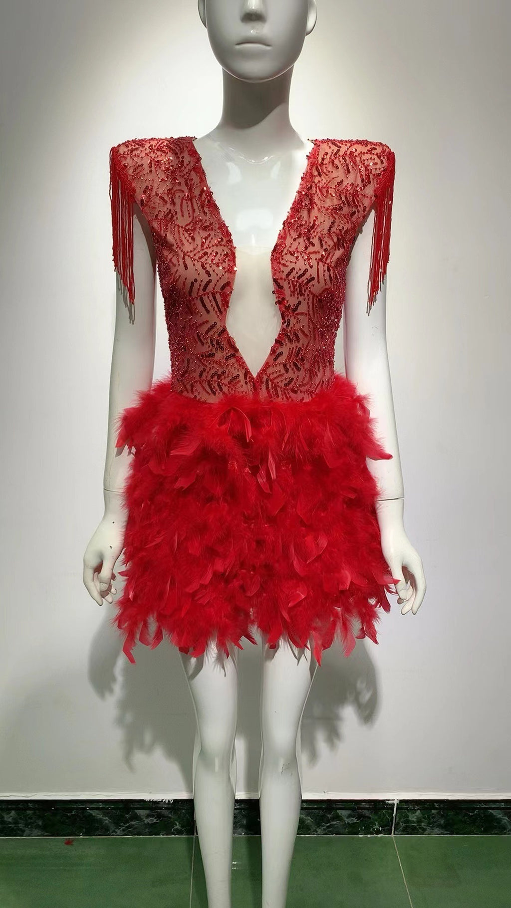 Robe courte sans manches rouge, décolleté en V profond, avec jupe à franges et plumes