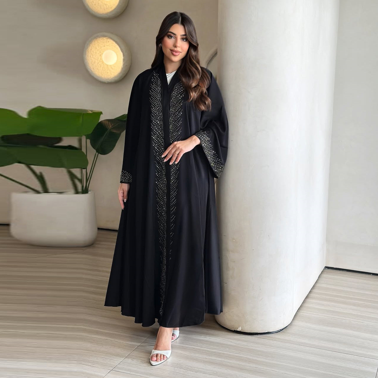 Robe noire élégante du Moyen-Orient avec ornements en strass et manches évasées