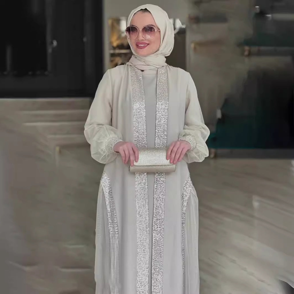 فستان فضفاض بأكمام طويلة ولون مشمشي سادة مزين بحلي لامعة