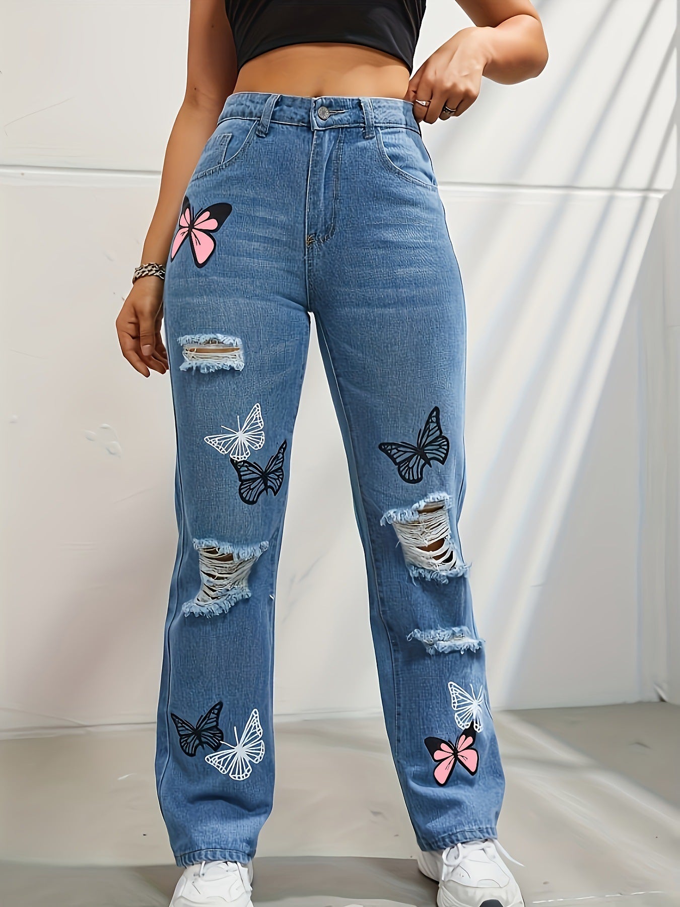 Jean droit taille haute en denim bleu pour femme avec imprimé papillon et déchirures usées
