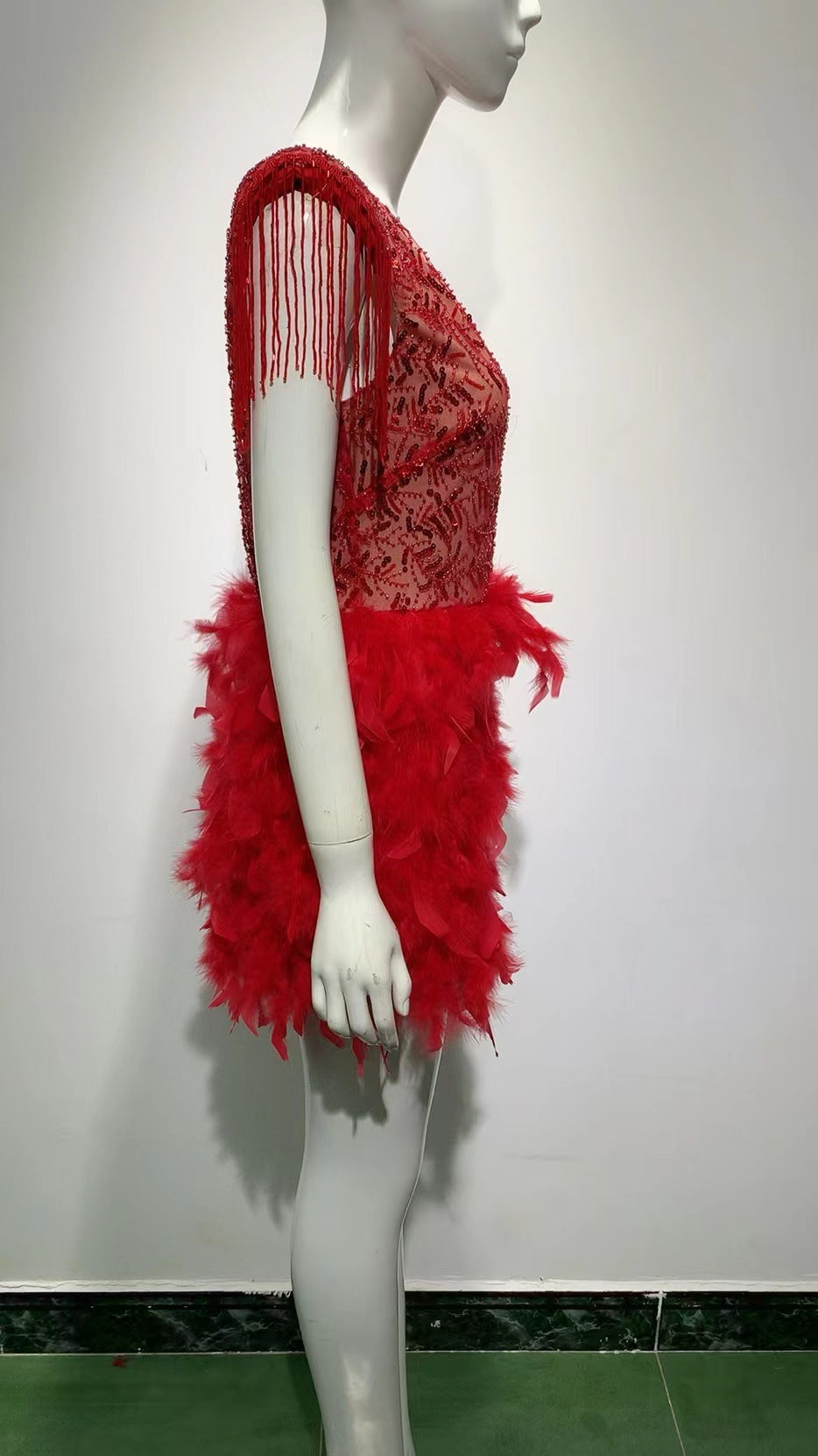 Robe courte sans manches rouge, décolleté en V profond, avec jupe à franges et plumes