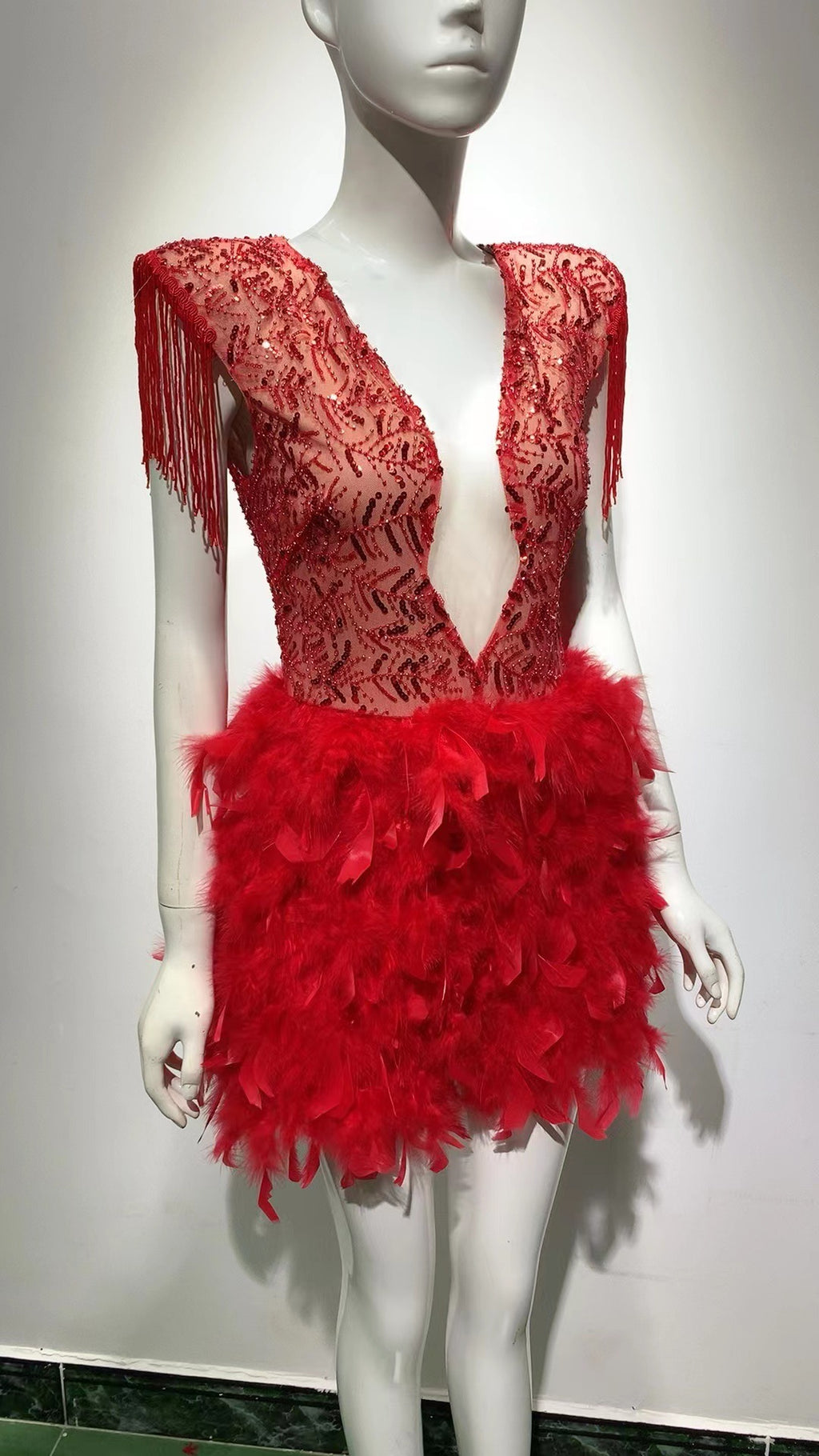 Robe courte sans manches rouge, décolleté en V profond, avec jupe à franges et plumes